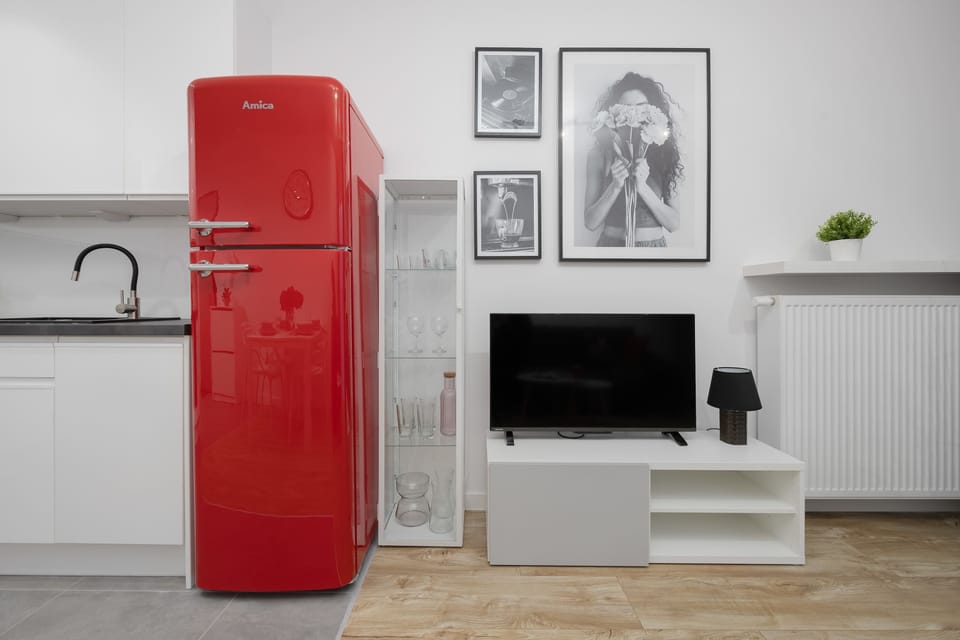 The modern kitchen with red accents and sleek finishes gives you freedom to cook and serve meals effortlessly.