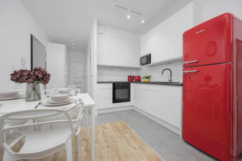 The fully equipped kitchen with a vibrant red designer fridge adds energy to your mornings and inspires culinary creativity.