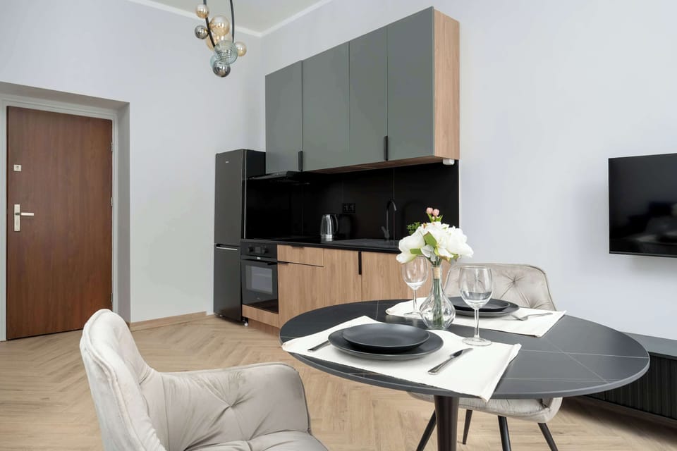 The minimalist layout of the kitchen and living room, with a visible TV and comfortable armchair, encourages both relaxation and remote work.
