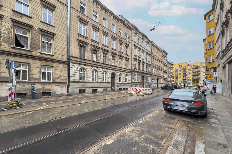 The street-level view reveals a calm one-way road with historic buildings and convenient parking spots.

