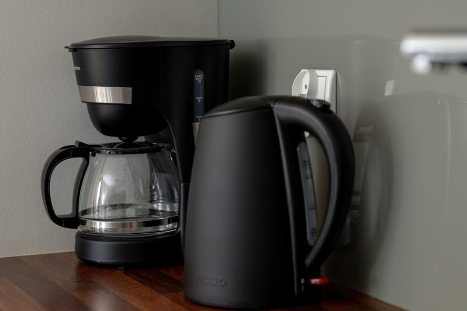 The coffee maker and kettle placed on the counter offer everyday morning convenience.

