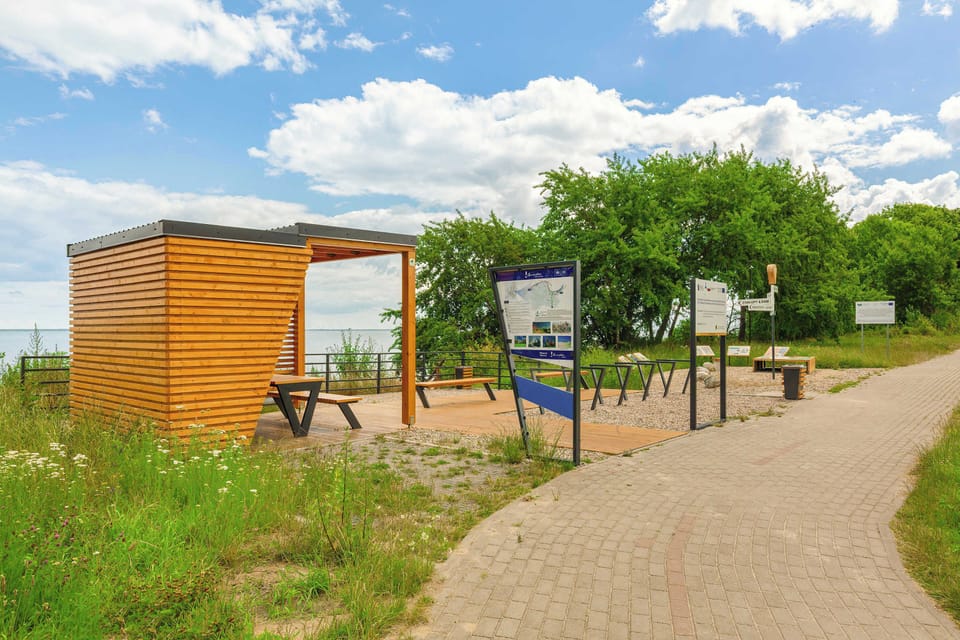 A charming walking path nearby with benches and information boards is perfect for relaxing outdoors.
