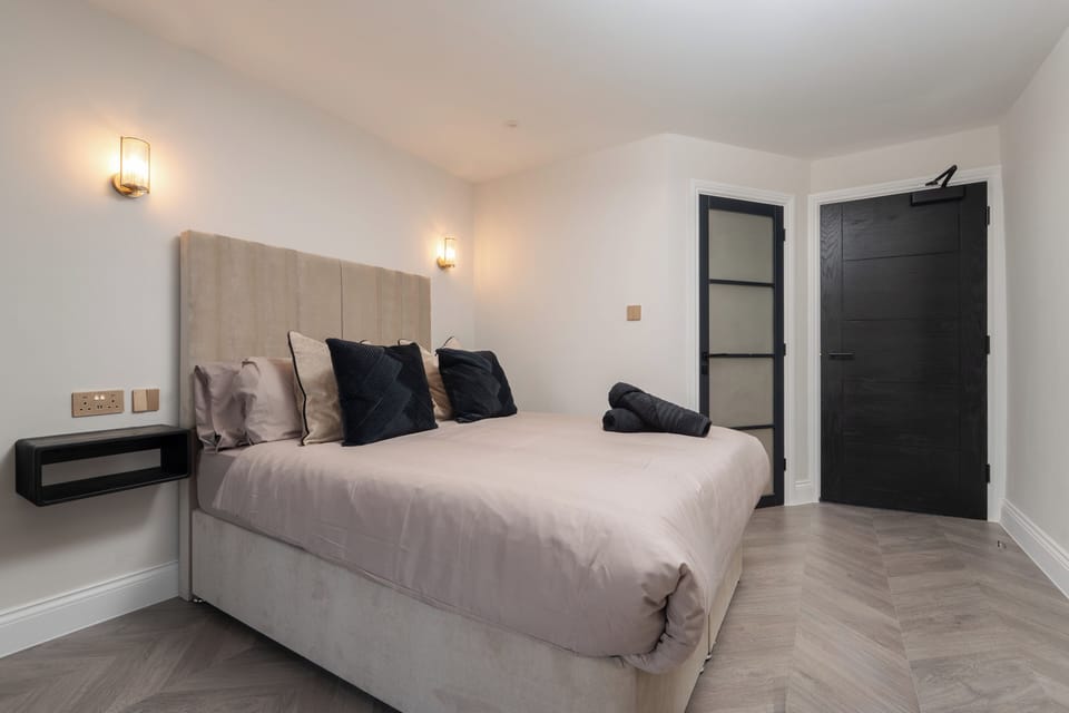 A bright, open-plan space featuring a comfortable double bed, vanity unit with mirror, wardrobe, Smart TV, and electric heater—perfect for relaxing or getting ready for a night out in the city.
