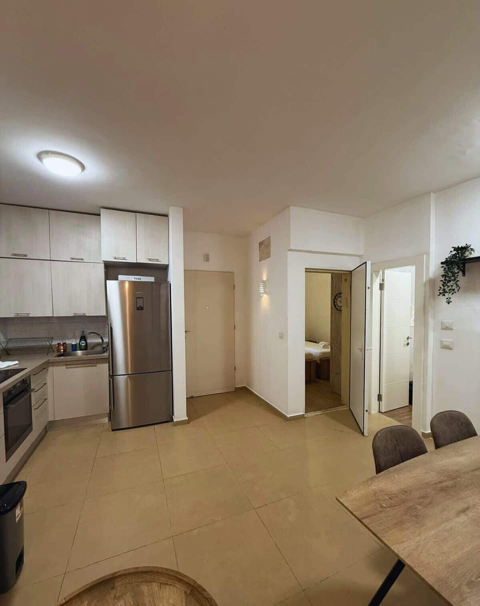 Open kitchen and dining area with modern appliances, ample storage, and direct access to the bedroom and bathroom.