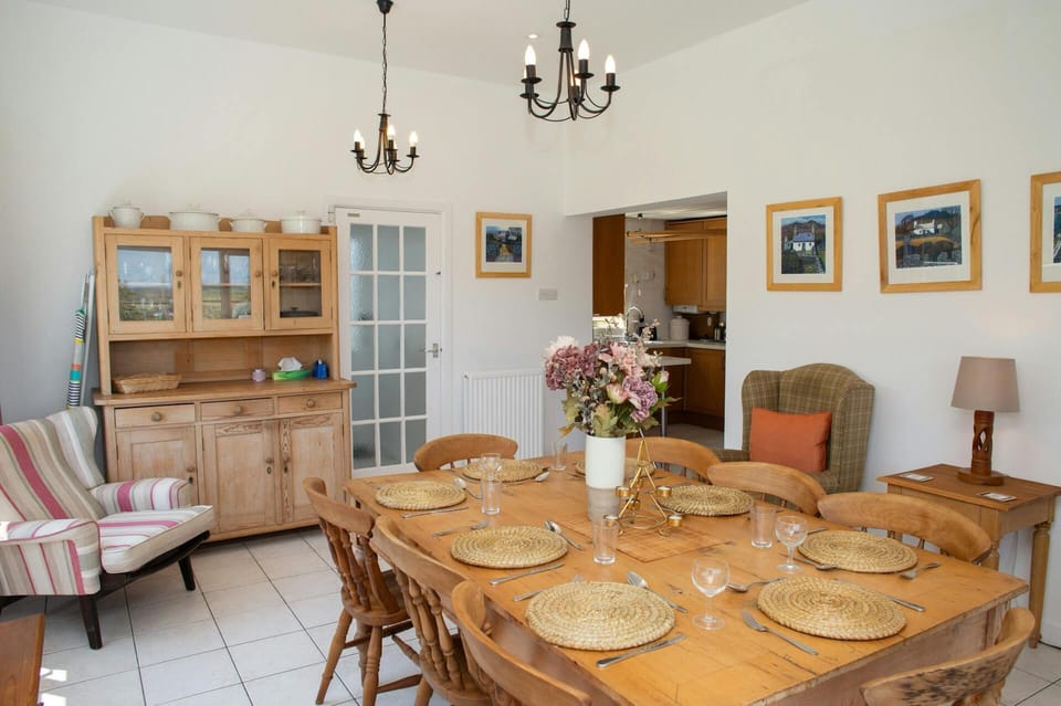 Dining room with Welsh Dresser and table seating 8 and 2 armchairs
