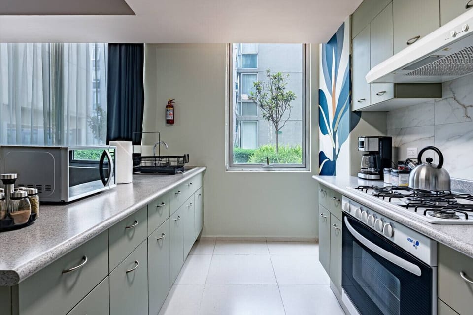 A bright and functional kitchen featuring light-colored cabinetry and stainless steel appliances