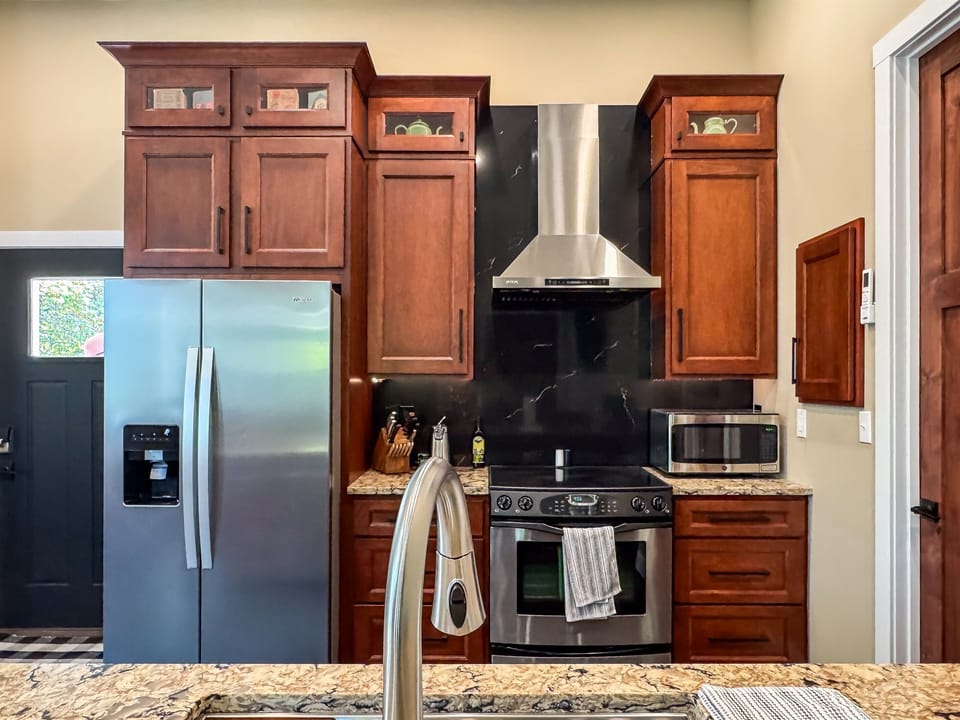 Full kitchen with ample counter space, kitchen tools, small appliances, and main entry door.
