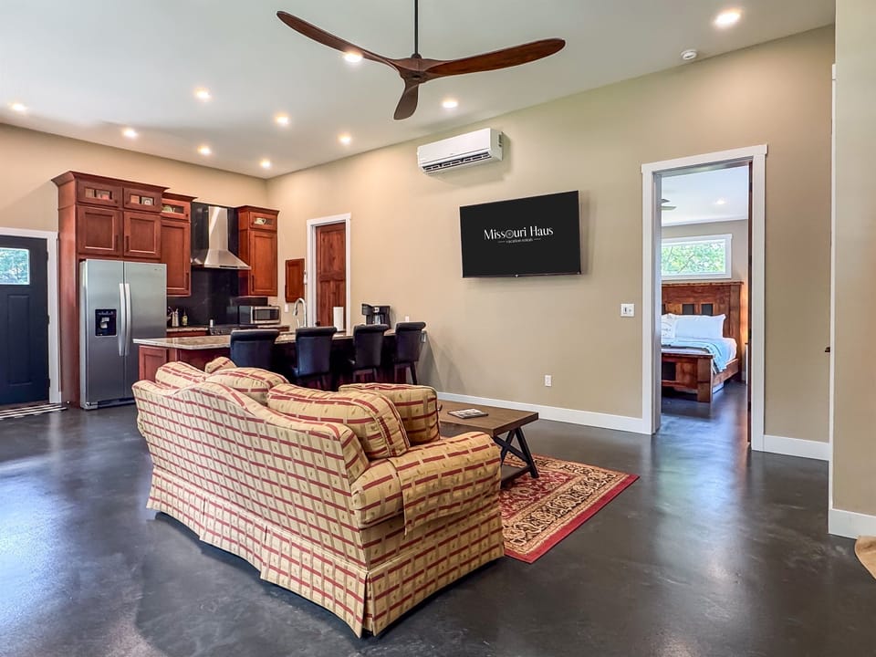 Main living area with smart tv, open concept kitchen/dining and bedroom access at Pikes Peak Schoolhouse.