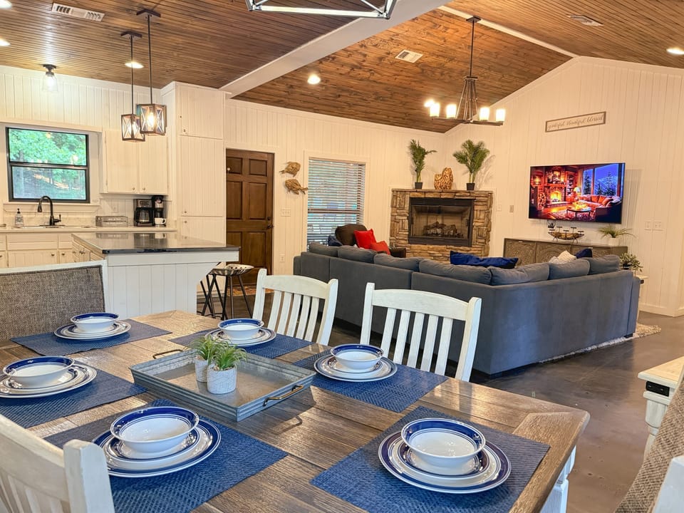 Spacious open floor plan with cozy seating, rustic fireplace, and fully stocked kitchen—perfect for gathering the whole crew.