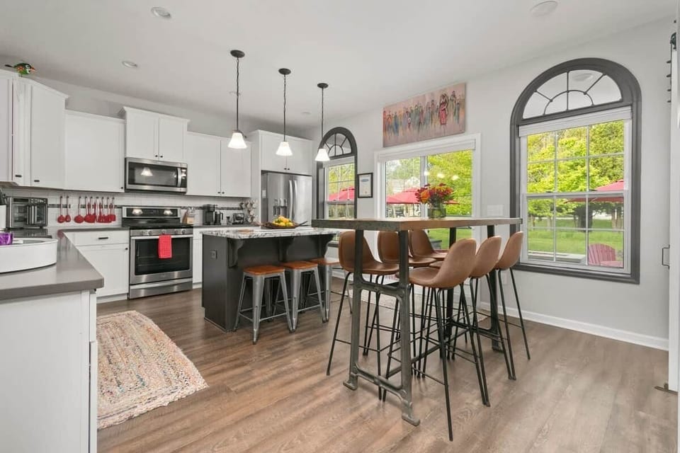 Modern fully stocked kitchen with large island, stainless steel appliances, and seating for family gatherings and entertaining.