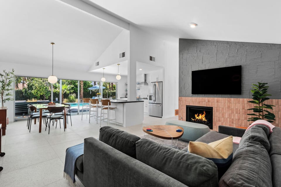 Open-concept living with fireplace & poolside access