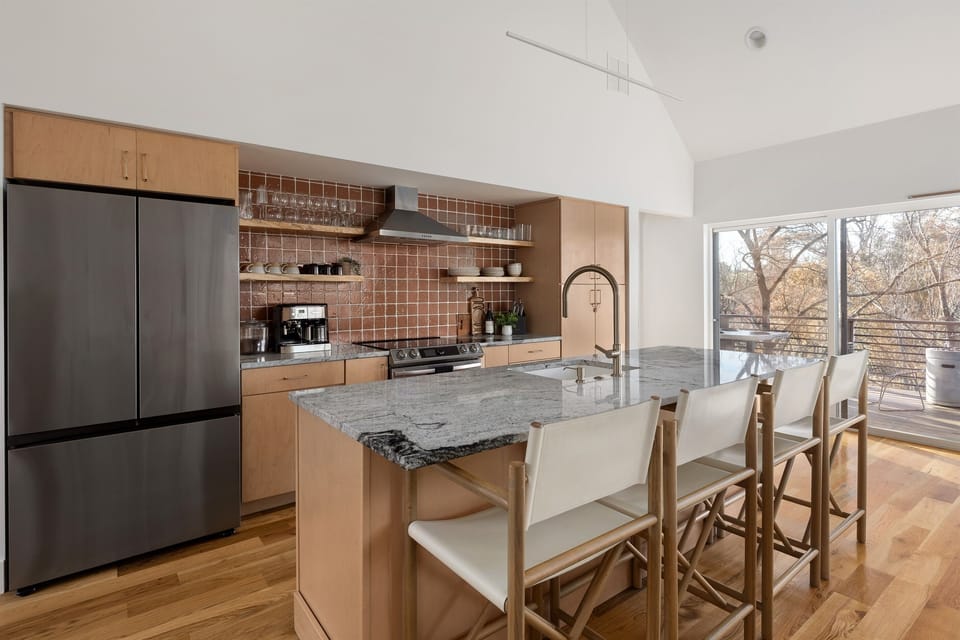 {Kitchen} A chef-inspired kitchen with a quartz island, stainless appliances, coffee bar, and seating for effortless mornings together.