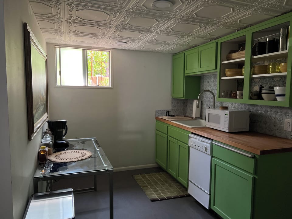 full kitchen with window (view of tomato garden) and coffee bar