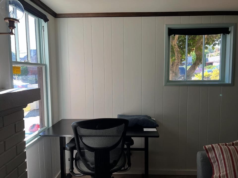 stand or sit at the office desk in the corner