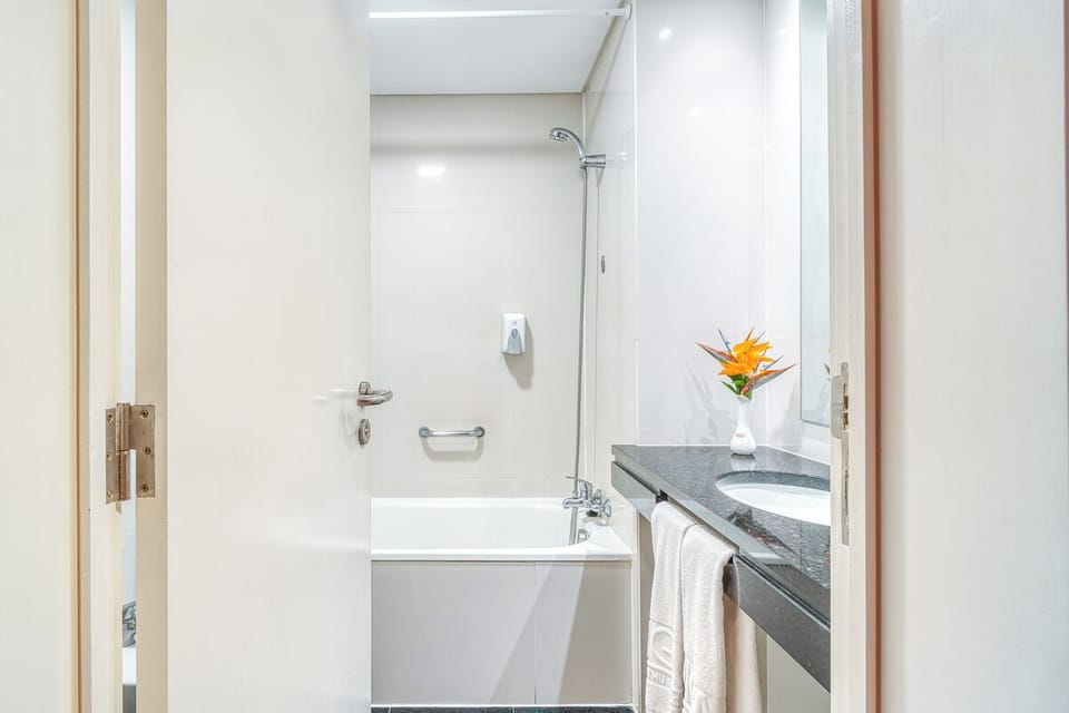 Refresh in a spotless bath with bright vanity and tub.
