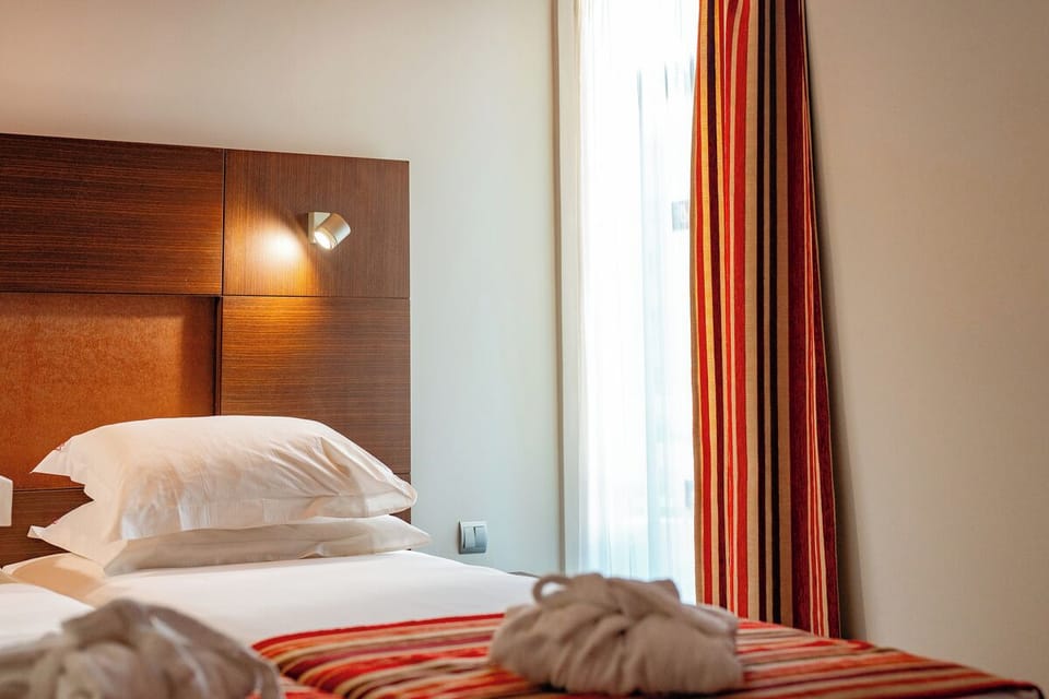 Wake gently with sunlit curtains and plush pillows nearby.
