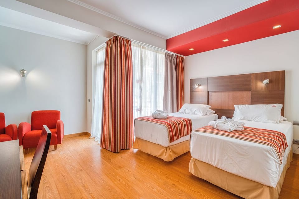 Unwind in crisp twin beds beneath warm, modern lighting.