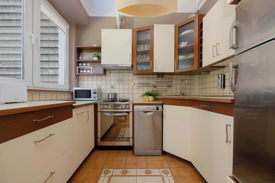 A modern kitchen with wooden cabinets, granite countertops, and stainless-steel appliances.