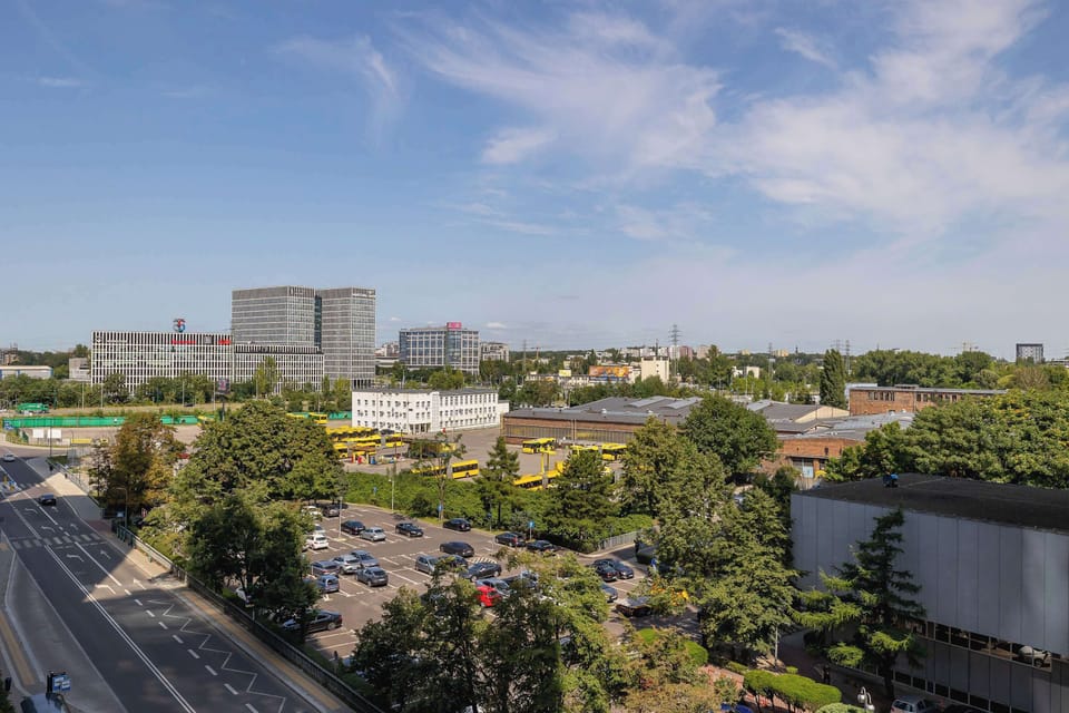 View from the balcony over the city, showing the skyline with tall buildings and a wide perspective.
