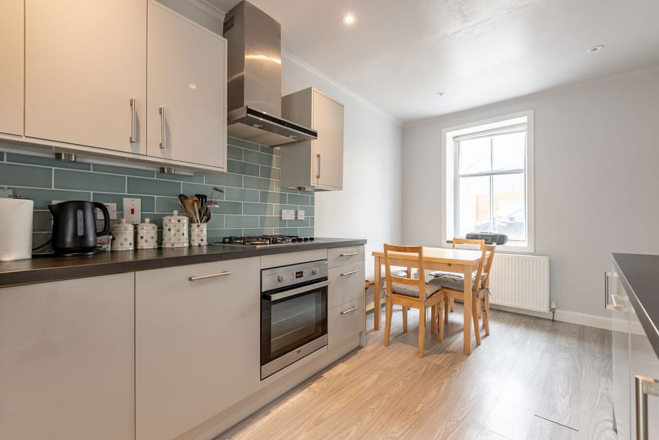 Bright kitchen with gas hob and dining table by the window at Earls Lodge near St Andrews and Elie links golf.