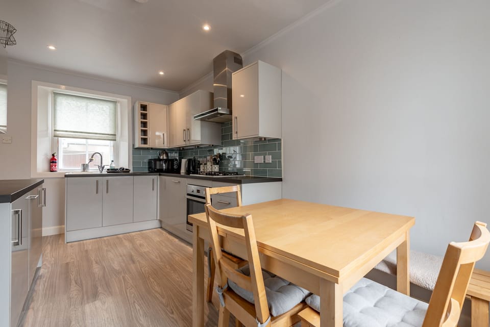 Spacious kitchen-diner with oven, hob and wooden table at Earls Lodge—ideal base for East Neuk golf.
