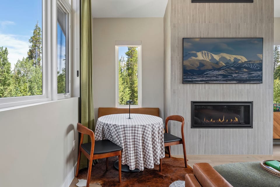 - Dining nook with round table by the fireplace   - Natural light through tall windows enhances charm   - Perfect corner for morning coffee or evening meal