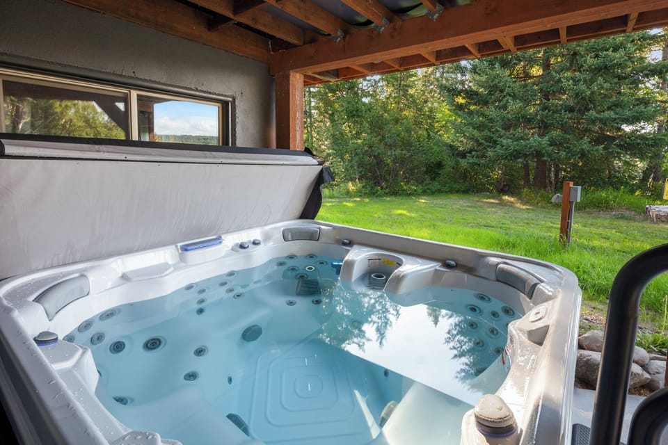 The spacious hot tub on the covered lower patio with beautiful views offers the perfect spot for unwinding in any weather. A relaxing way to end the day after exploring Montana’s Rocky Mountains or Glacier National Park.