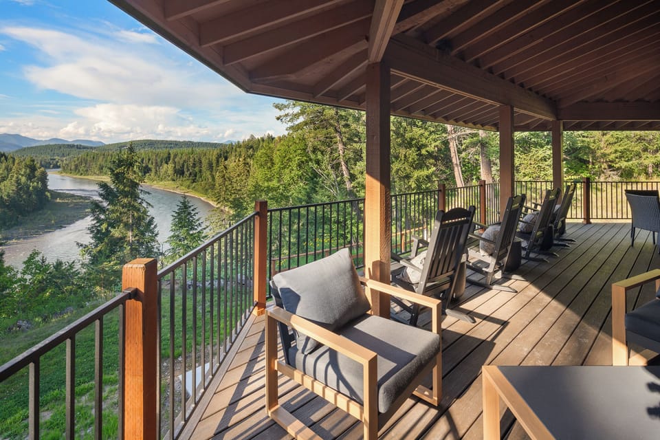 Covered deck with comfortable rocking chairs overlooking the Flathead River and Rocky Mountains near Glacier National Park. Ideal for morning coffee, sunset views, and relaxing after hiking, fishing, or exploring Montana.