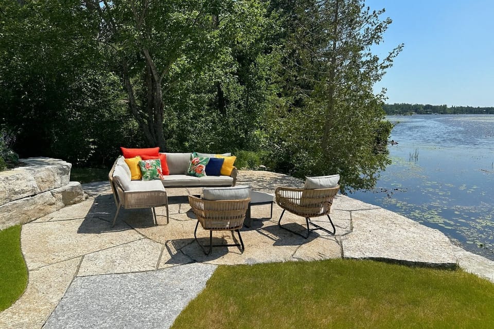 Stone patio tucked beside the lake, with cozy seating for relaxing lounging just steps from the water.