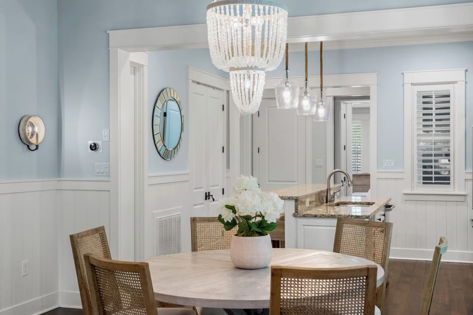 Dining space looking into the kitchen, highlighted by statement lighting & a clean, open layout.