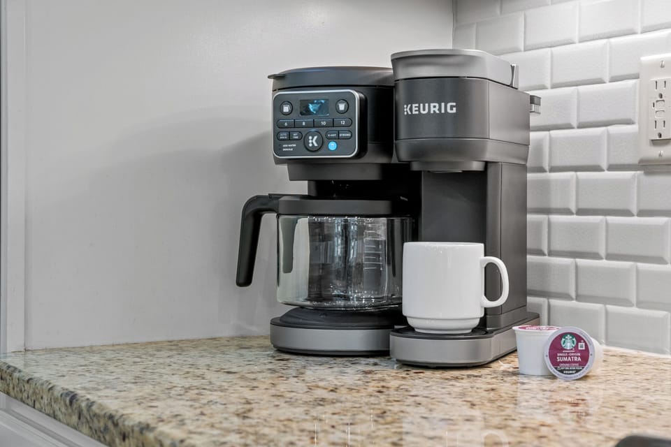 Coffee setup w/ Keurig, mugs & pods ready to jumpstart slow mornings.
