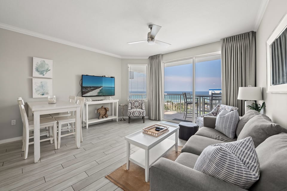 Open living space w/ comfy seating and coastal tones, ideal for relaxing together.