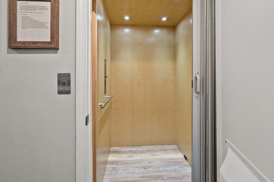 Elevator with wood-lined walls and a handrail at Wells Tales, a Cherry Grove beach house rental