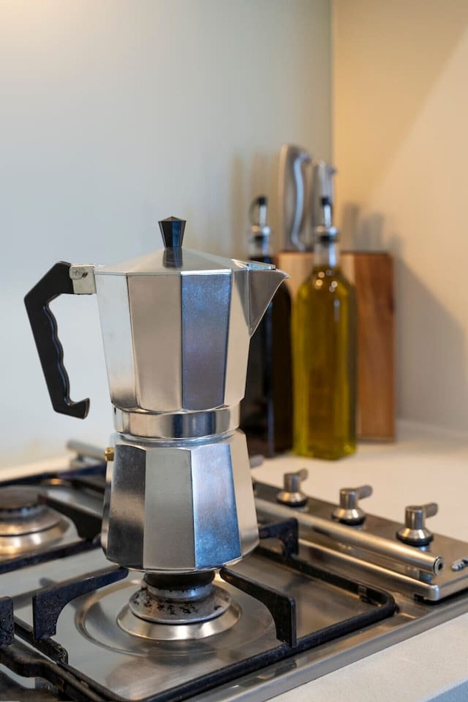 Classic stovetop espresso maker on a modern gas cooktop, perfect for brewing fresh coffee at home. A simple, stylish setup for starting your day with a rich, aromatic cup.