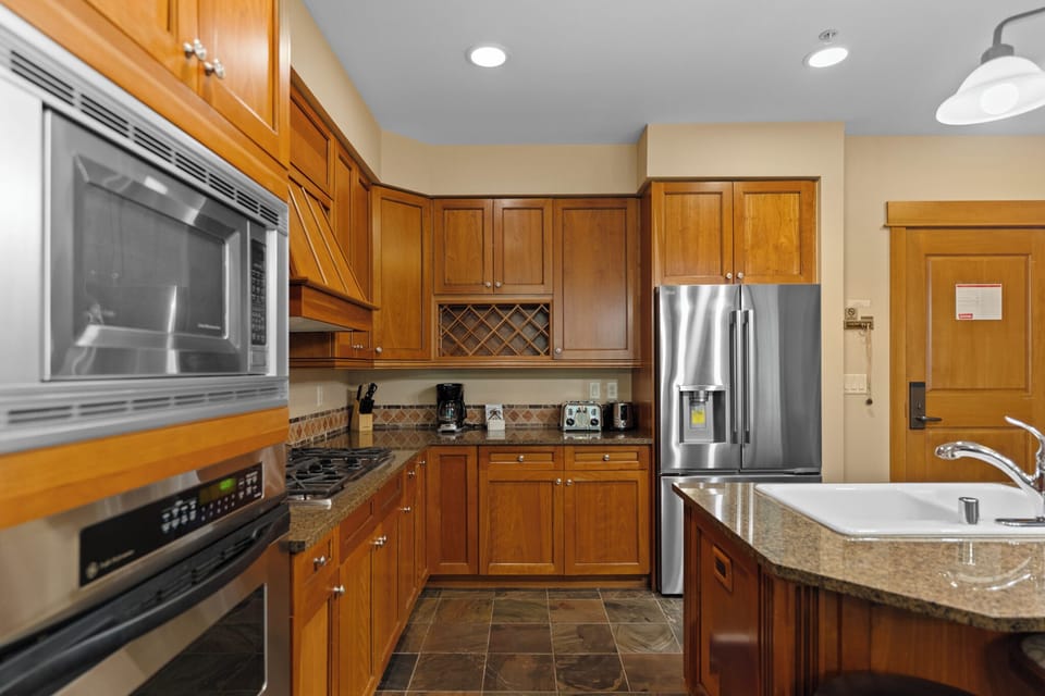 Your spacious kitchen features granite counters, stainless steel appliances, and rich wood cabinetry—perfect for preparing meals during your stay.