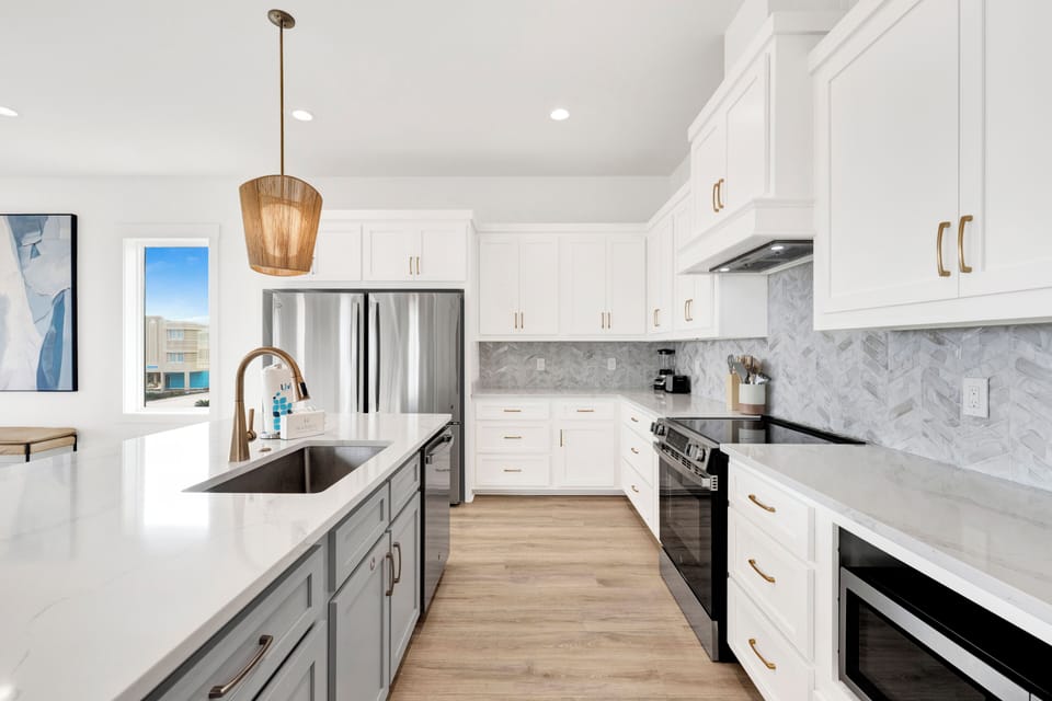 Stainless steel appliances, stone counters and two refrigerators