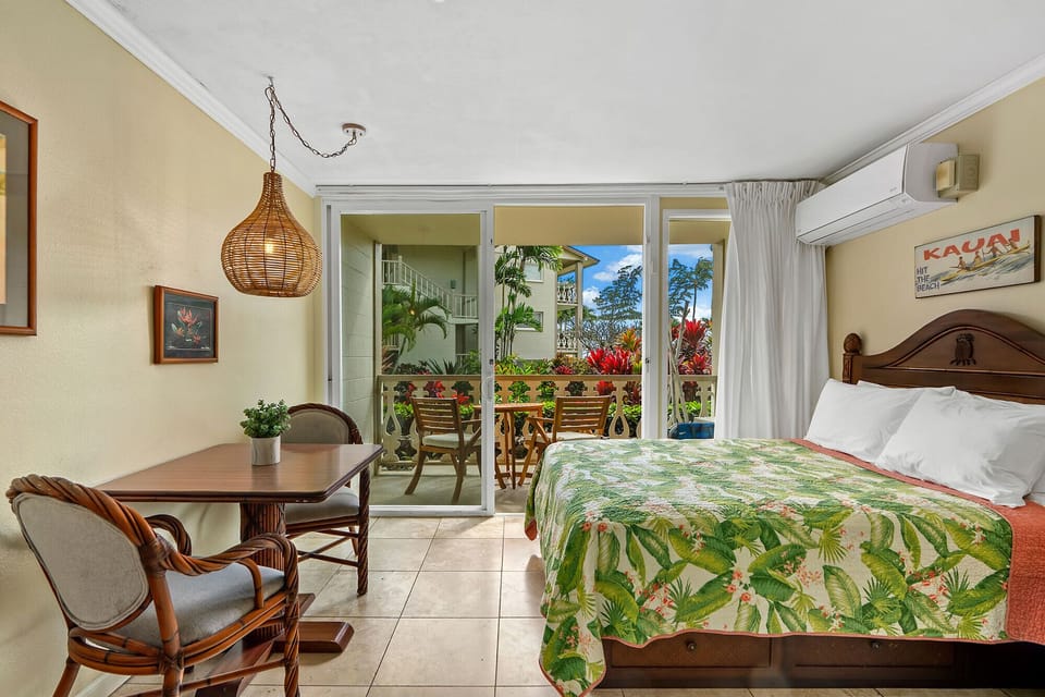 Your tropical bedroom retreat opens to a lush balcony where tropical breezes and garden views create the perfect island escape.