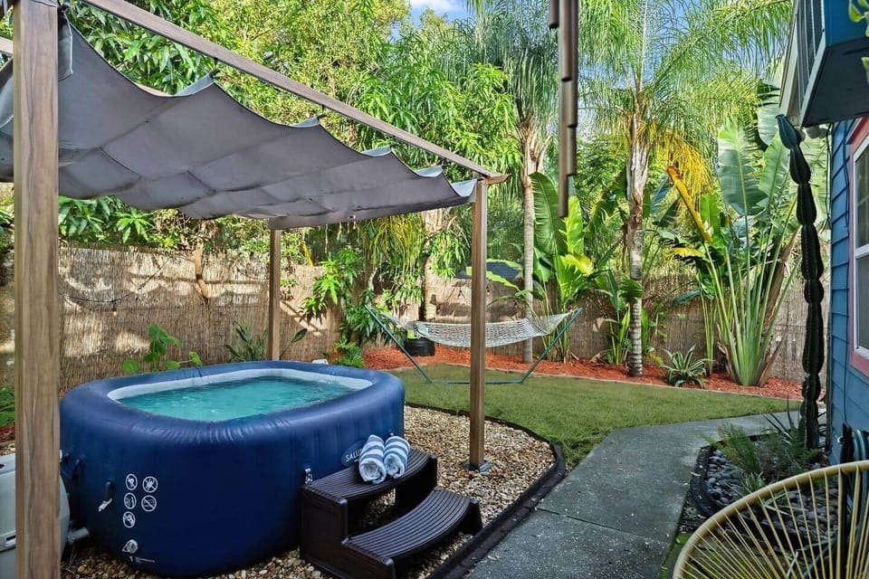 Spacious backyard that's fully private and fenced in. Saluspa Hot Tub, Hammock, Mango Tree, Lush Mature Tropical Plants, String lights for Nighttime Relaxation, Outdoor Chairs.