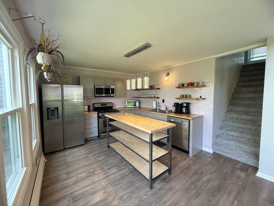     Open-concept kitchen with staircase & dining view
