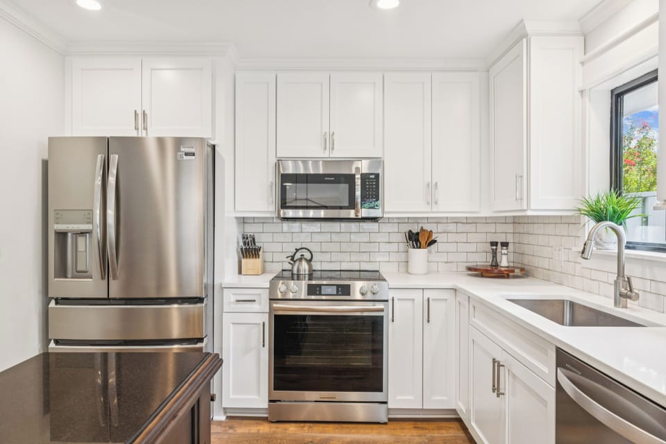 Fully equipped kitchen featuring a flat top stove, stainless steel appliances, and plenty of counter space