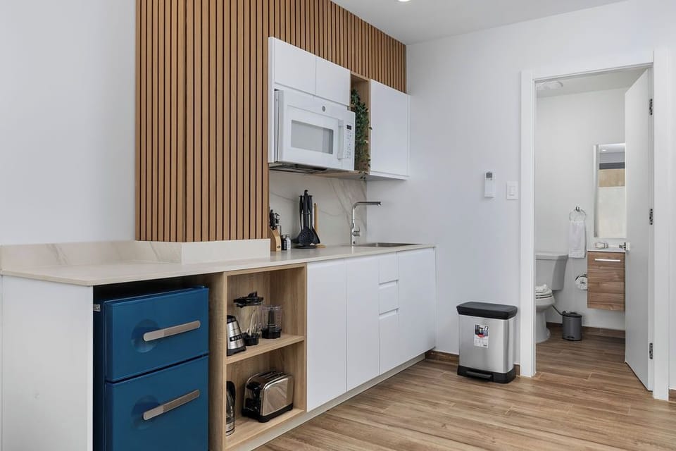A stylish view of the kitchen and bathroom, both elegantly designed with wooden accents and equipped with a microwave oven for your convenience.