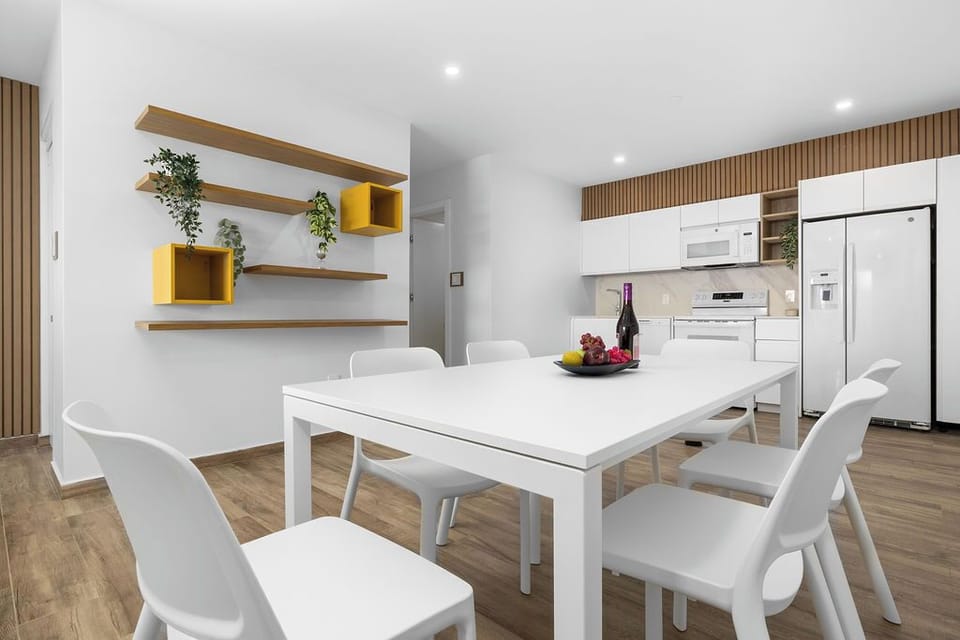 A warm, contemporary dining area with a spotless table for six, ideal for enjoying delicious meals with family and friends.