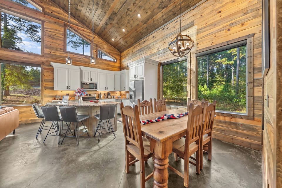 Gather for meals in this bright kitchen with forest views and rustic charm