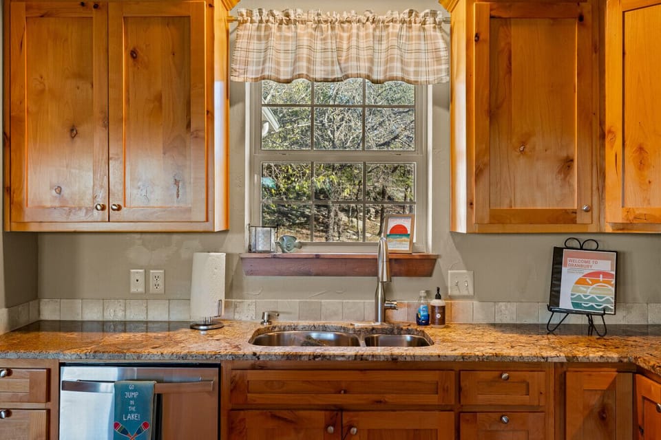 Kitchen Sink View | Granite Countertops | Warm Wood Cabinetry | Scenic Window Outlook