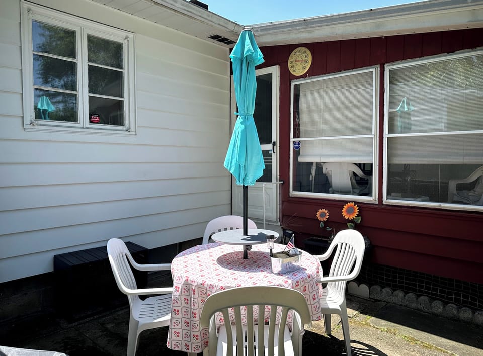Patio table with 4 chairs and umbrella. Just 2 steps down off enclosed porch.