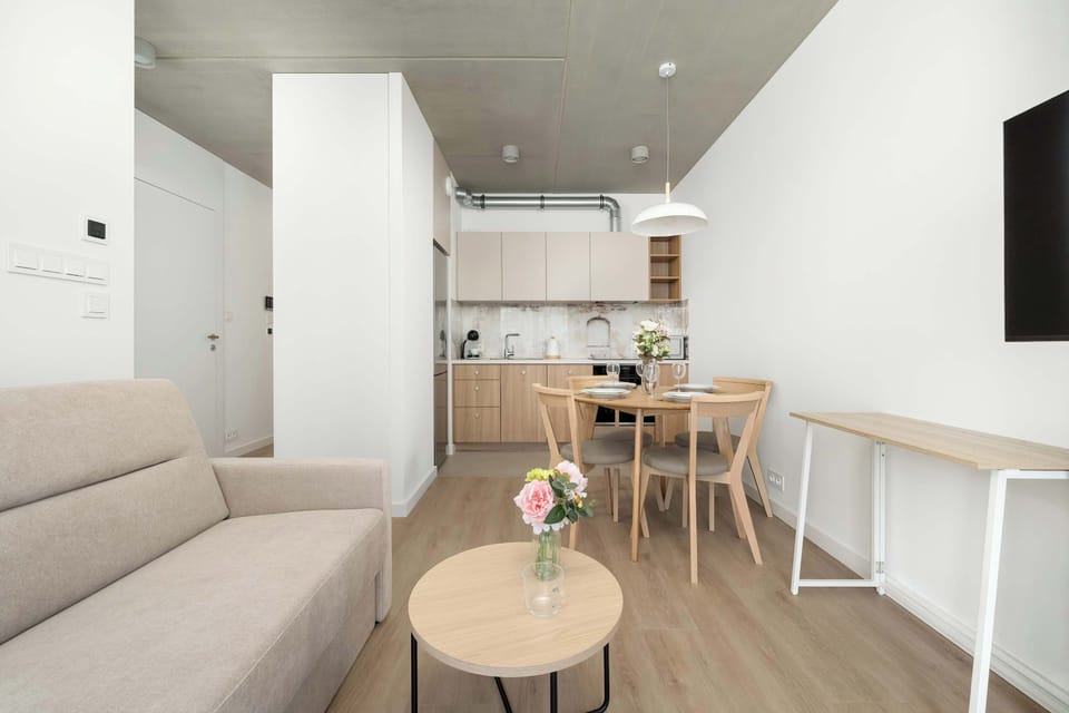 A living room with a comfortable sofa and a view of the open-plan kitchenette. The space feels bright and welcoming.