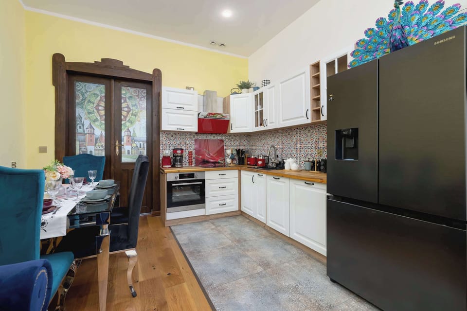 A bright kitchen with a spacious countertop and contrasting black fridge, encouraging culinary creativity.