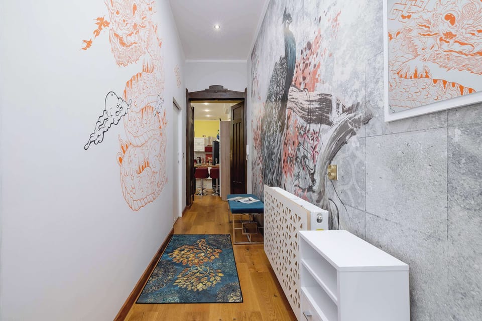 A hallway with decorative wallpaper and modern lighting sets the mood for the apartment.
