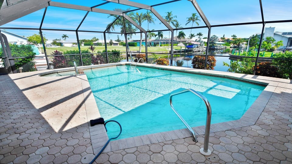 Pool with canal view – relax under palm trees with direct access to the water.