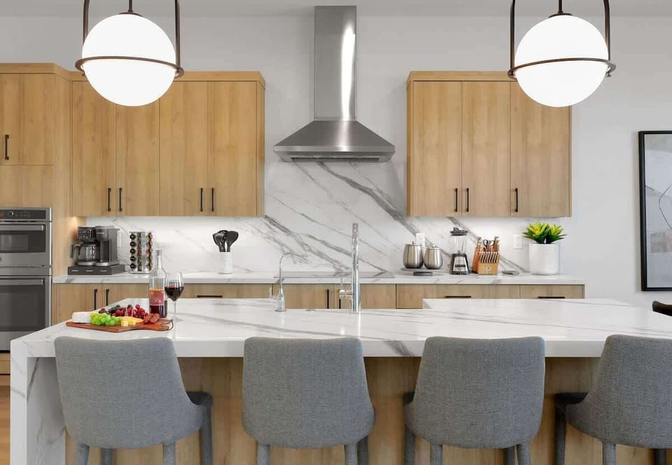 Fully equipped kitchen with stainless steel appliances, a sleek kitchen island with a breakfast bar for casual seating for 4, plus a large dining table for 10. (1st Floor)